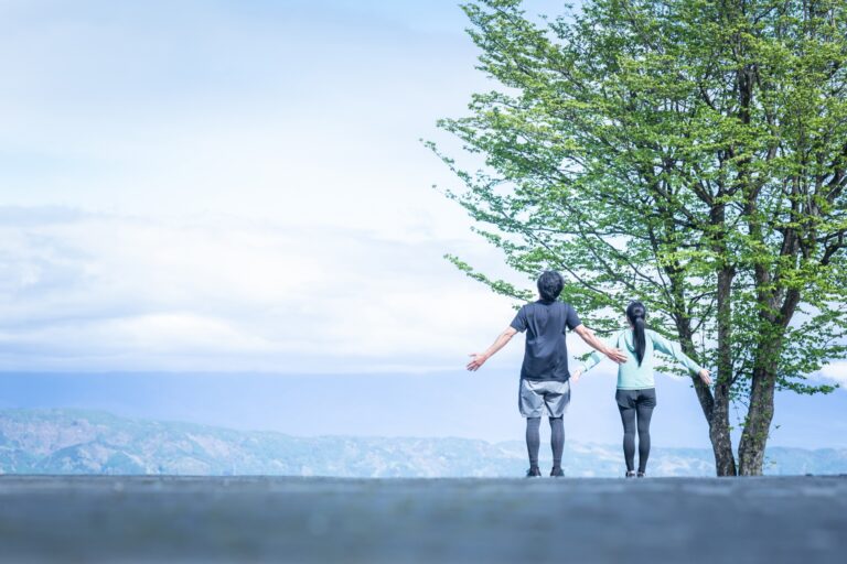 自然の中で深呼吸し気持ちを整える二人の後ろ姿