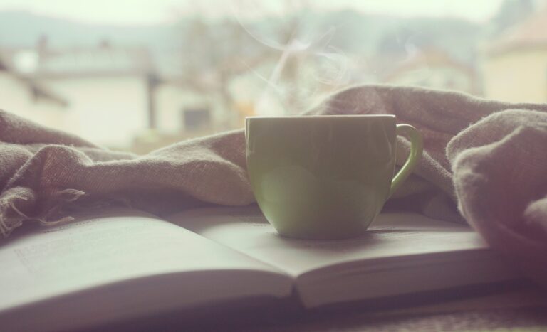朝の静かな時間に本とコーヒーを前に気持ちを整えるイメージ
